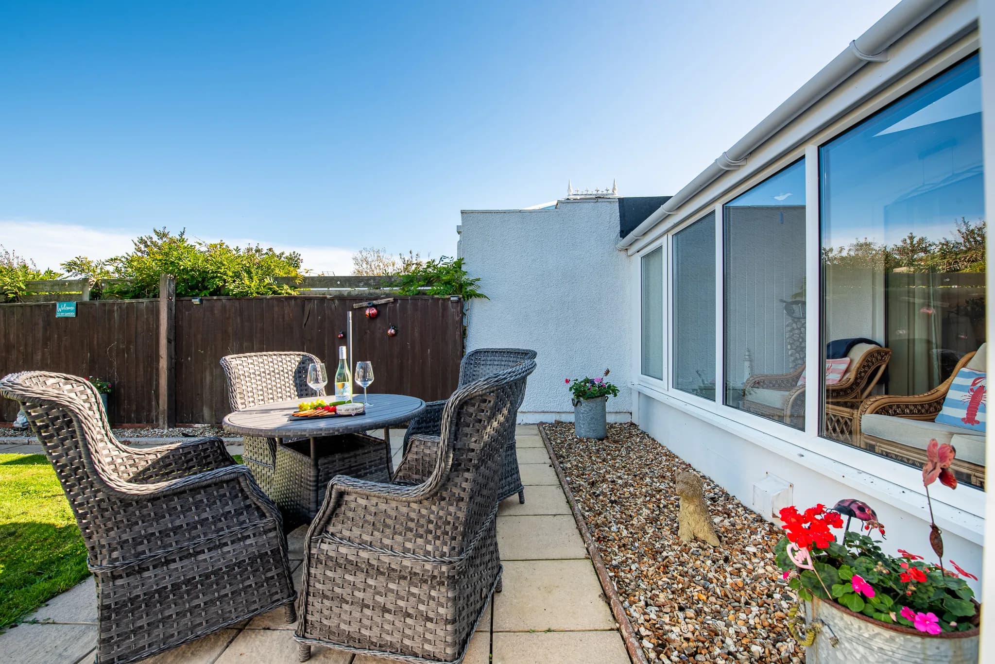 Patio seating beside the porch in the rear garden at Sea Dreams
