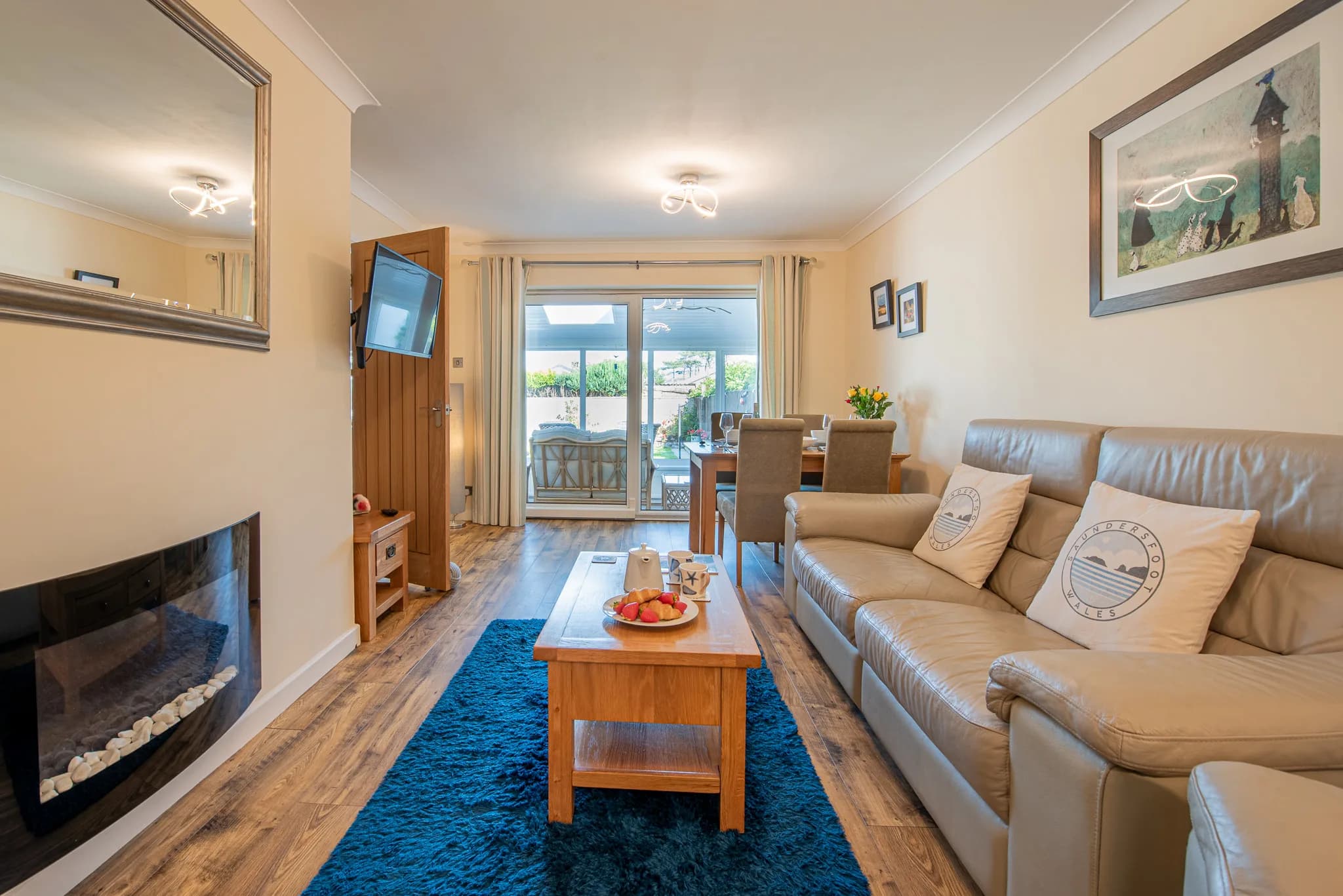 Living room with electric fire, looking through to the dining area at Sea Dreams