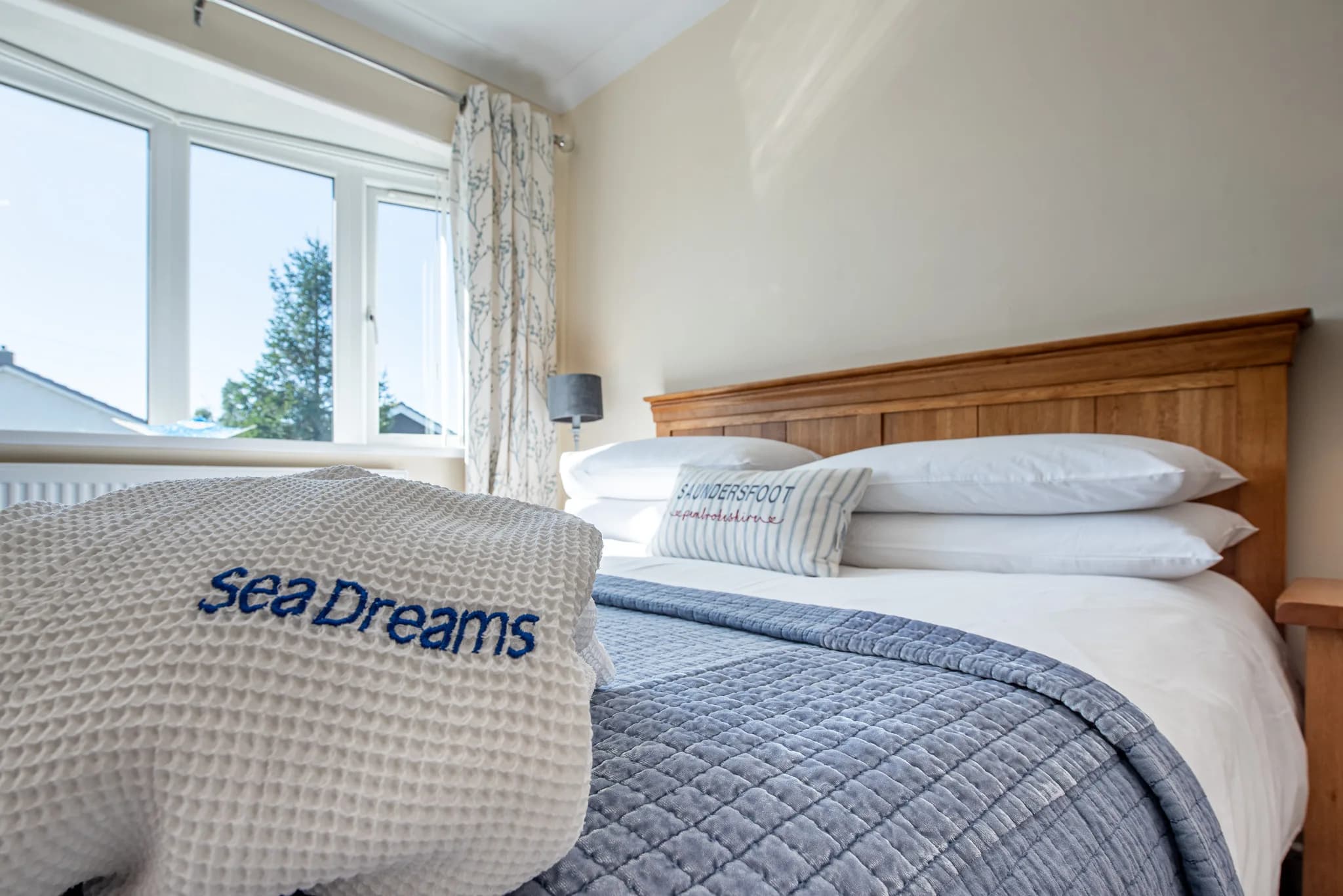 Kingsize bed made up with a Sea Dreams robe in the master bedroom