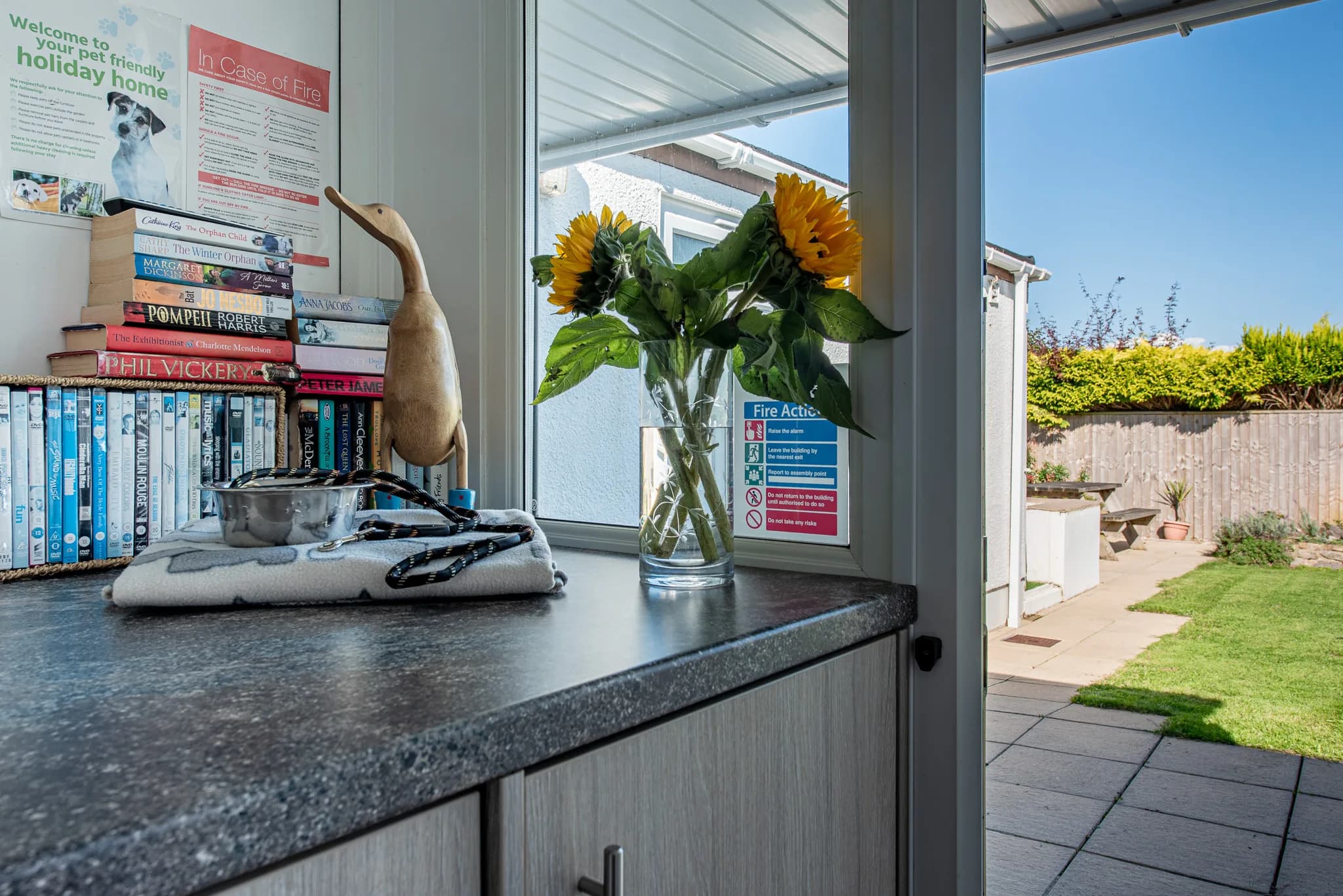 Porch with books and games, looking onto the garden at Sea Dreams