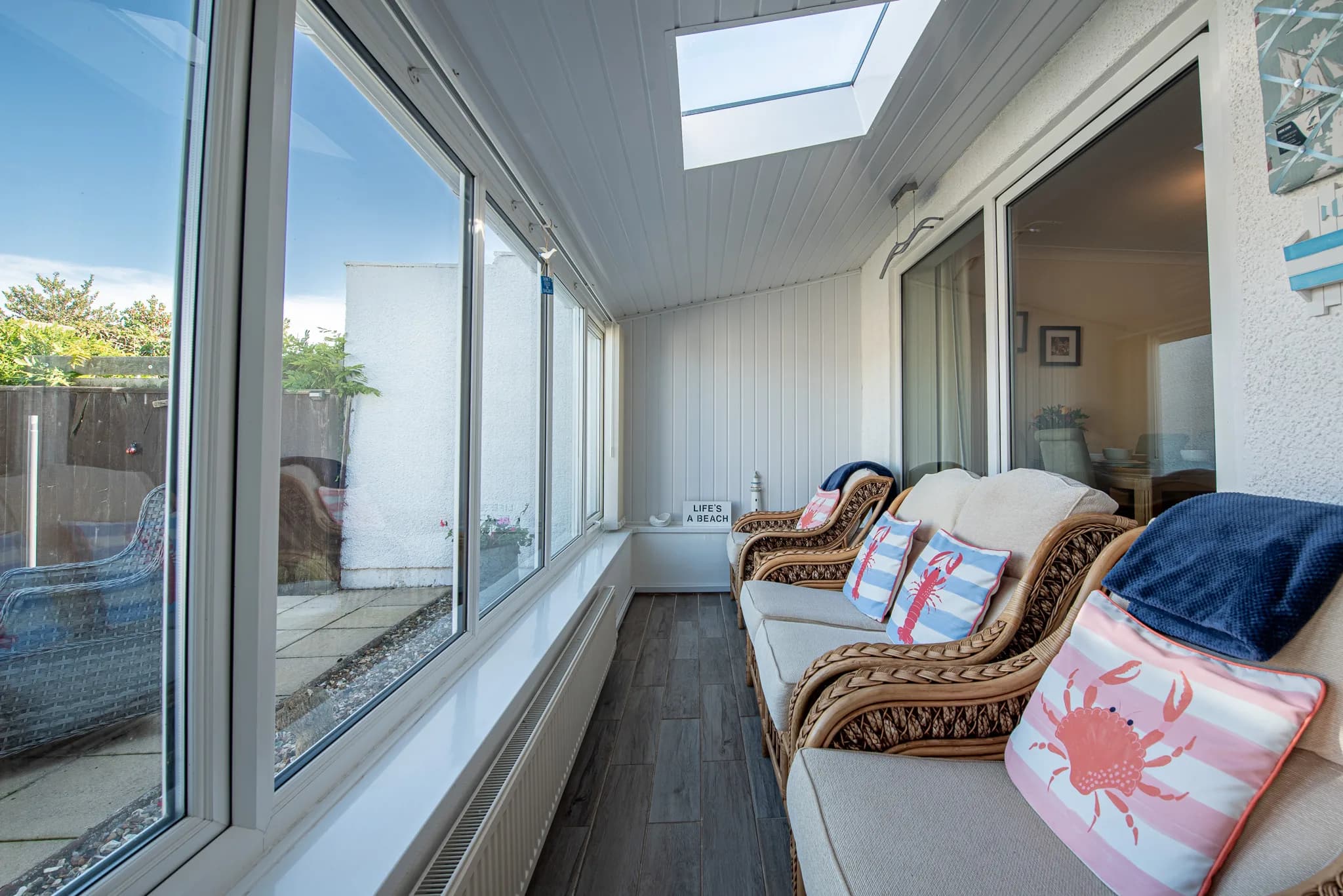Porch seating area with cushioned wicker sofa at Sea Dreams